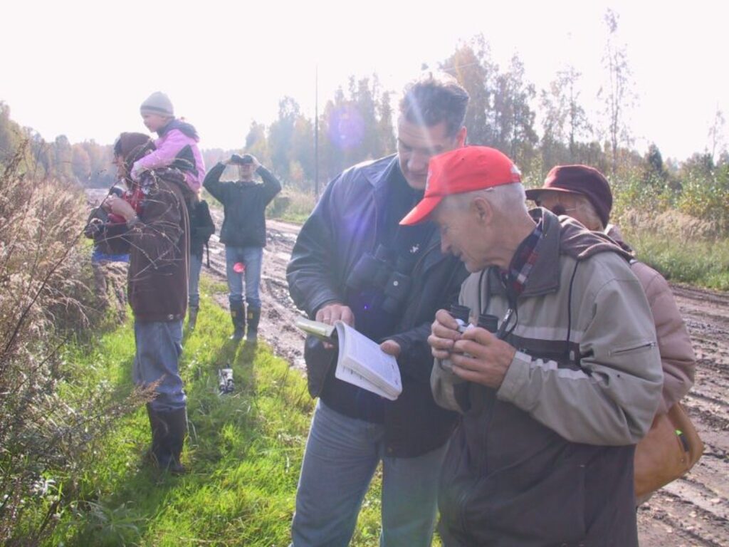 Gids Dagnis Mukāns (no kreisās) un pieredzējis putnu vērotājs rīdzinieks Dzintars Gerics salīdzina putnu noteicējā, kādas sugas pārstāvi tikko redzējuši.
Autors: Sandra Pētersone