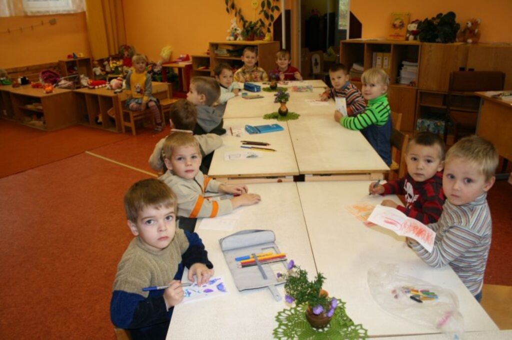 Bērni rotaļu istabā zīmē, silti saģērbušies.
Autors: Aivars Zilbers