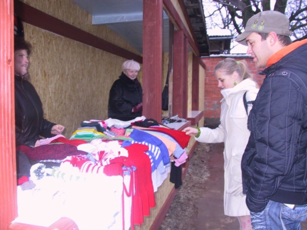 Egita un Edgars Grīnbergi no Saulkrastiem atbraukuši uz Smilteni apciemot radiniekus un Ziemassvētku gadatirgū meklē adītas zeķes un cimdus. Savu preci izrāda Ilze Lukstiņa (no kreisās). 
Autors: Sandra Pētersone