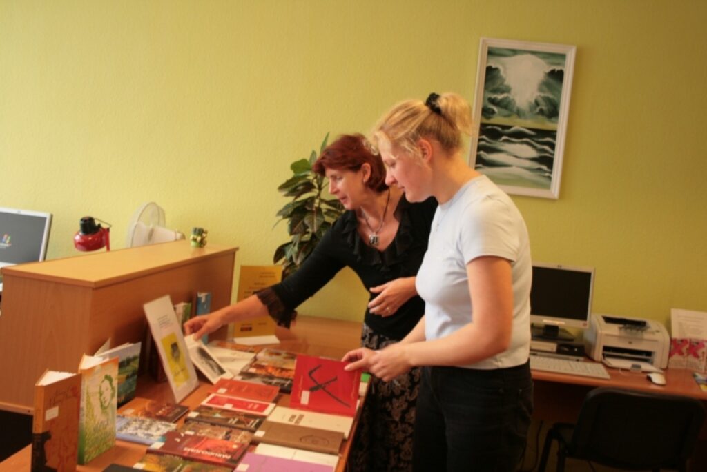 Valkas bibliotēkas vadītāja Ginta Dubrovska (aizmugurē) iepazīstina lasītāju ar izstādē izliktajiem krājumiem.
Autors: Aivars Zilbers