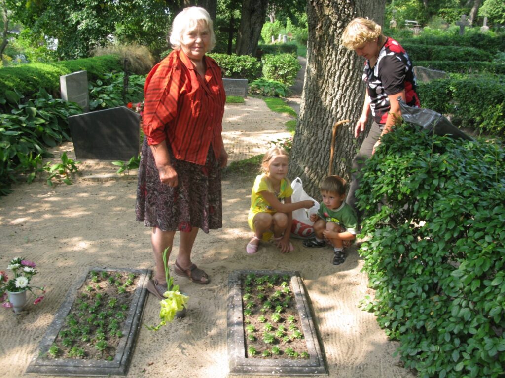 Arī Vilma Āboltiņa (no kreisās) ņēmusi uz Smiltenes kapsētu atvestās smiltis, lai sakoptu tuvinieku atdusas vietu. Āboltiņu ģimene, tāpat kā daudzi citi ļaudis, kapu svētkos ziedo naudu kapsētas sakopšanai. 
Autors: Sandra Pētersone