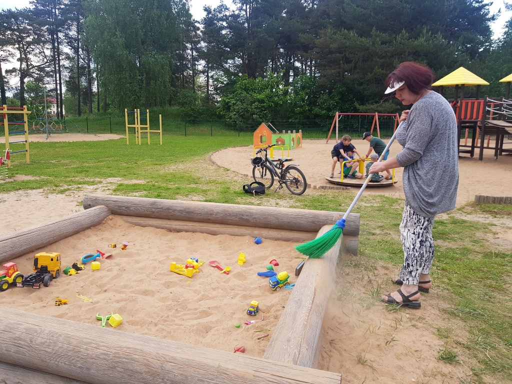 Dežurante Inga Reiniece katru dienu uzkopj rotaļlaukuma teritoriju. Viņa cer, ka pašvaldība smilšu kastei atvedīs dzeltenās smiltiņas, lai bērni varētu cept smilšu kūkas. 